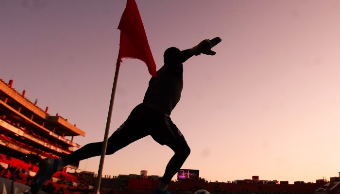 Un futbolista centra un balón al área