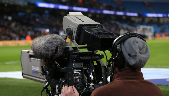Un operario de cámara graba durante un partido de fútbol